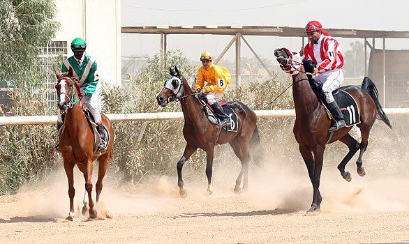 Jockeys get ready to race at the Baghdad Equestrian Club, where businessmen, tribal sheiks and working-class Iraqis rub shoulders.