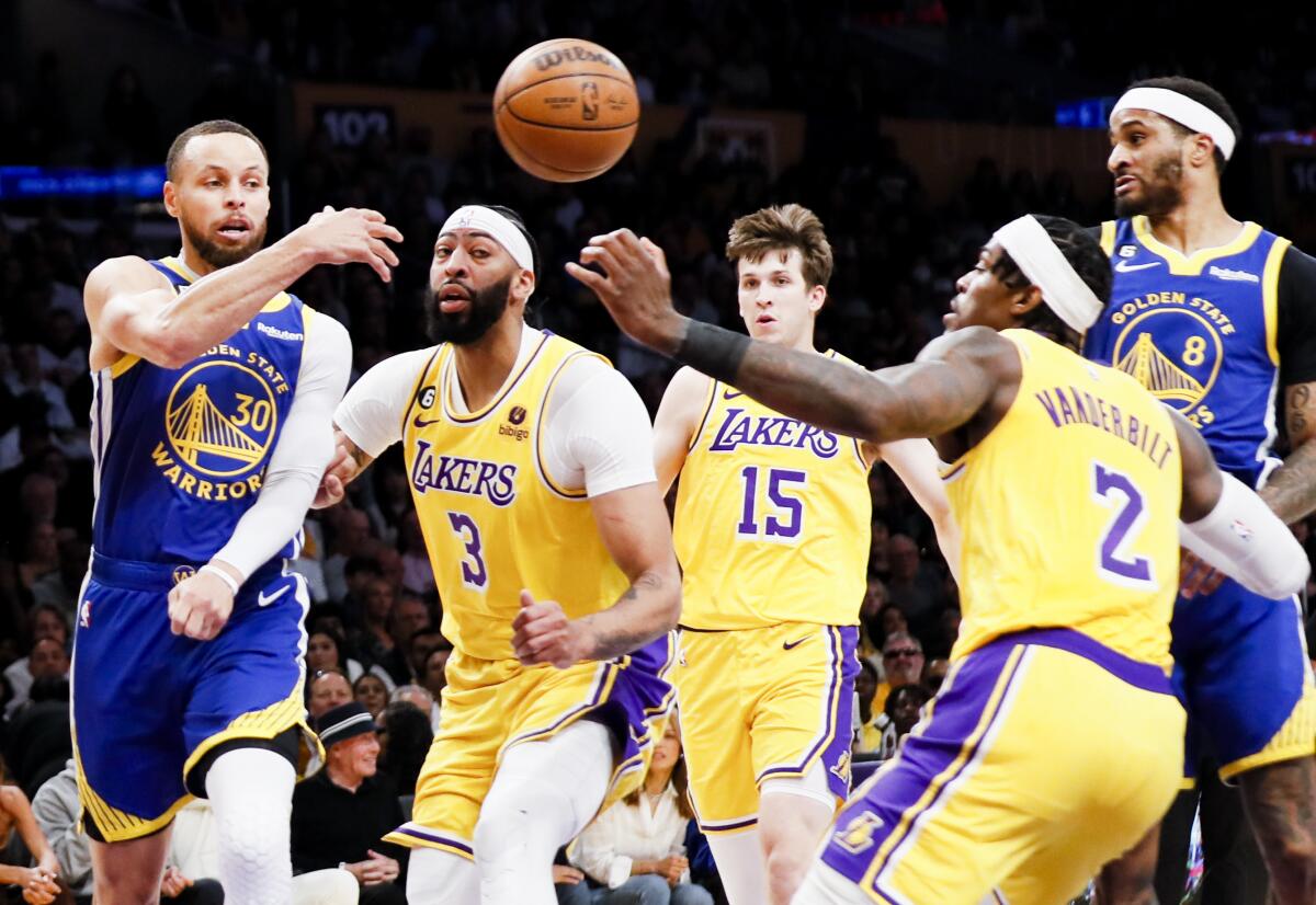 Warriors guard Stephen Curry is forced to pass while pressured by Lakers forwards Anthony Davis and Jarred Vanderbilt.