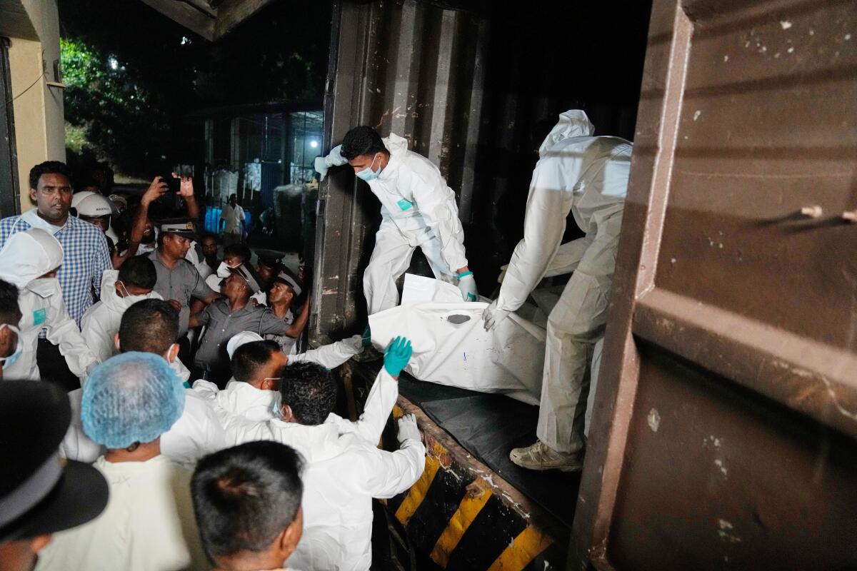 Healthcare workers unload the bodies of Iranian sailors.