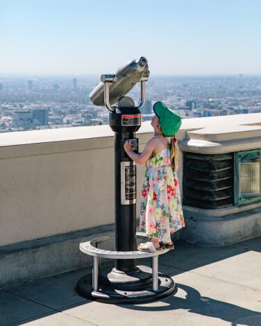 LOS FELIZ, CA - OCTOBER 3RD: A young visitor to Griffith Observatory try's her best to see downtown Los Angeles on Tuesday, October 3, 2023 in Los Feliz, CA. (Joel Barhamand / For The Times)