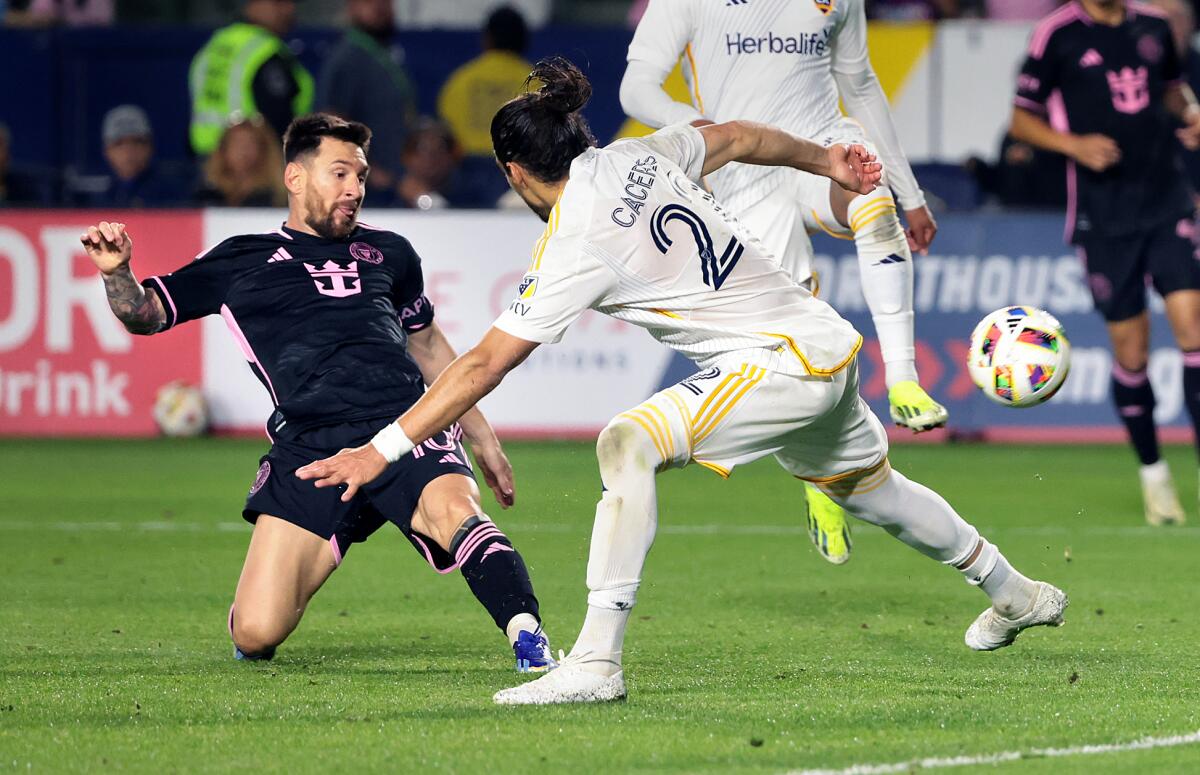 Inter Miami star Lionel Messi, left, shoots and scores in front of Galaxy defender Martin Caceres.