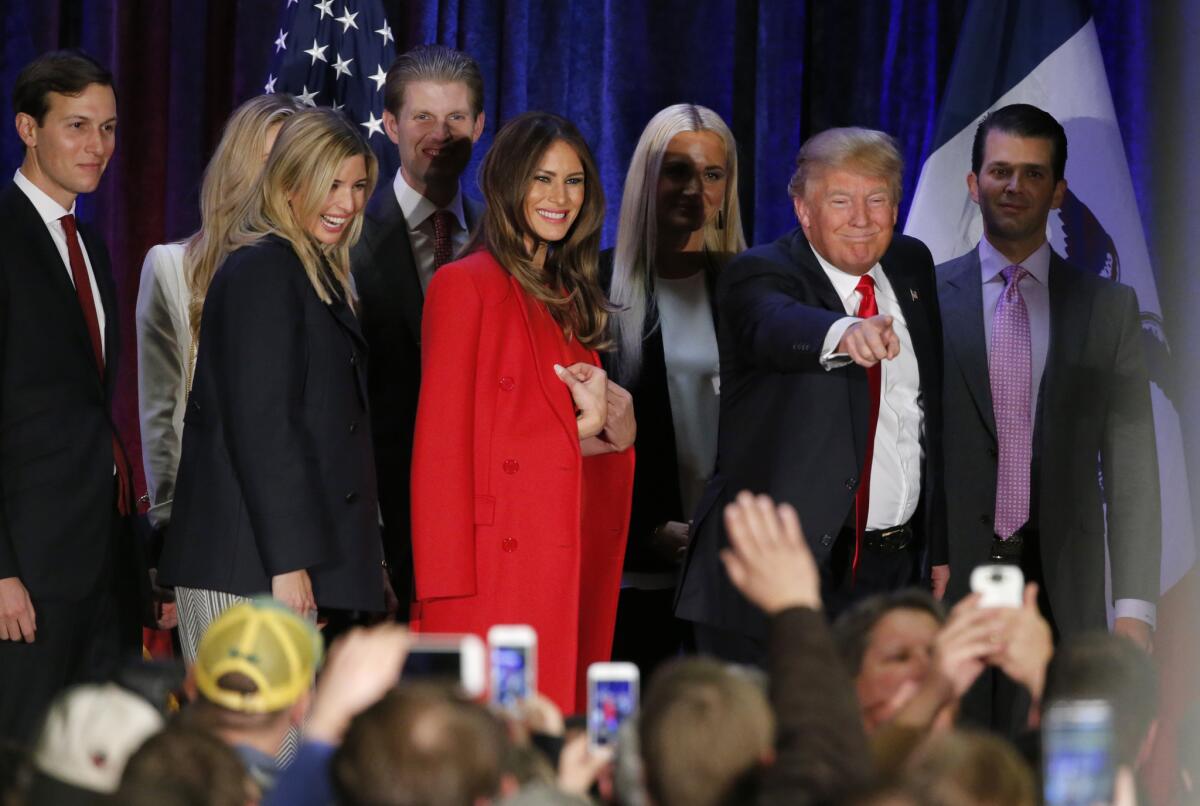 El empresario Donald Trump, aspirante a la candidatura republicana a la presidencia, señala a un seguidor mientras se marcha con su familia de su mitin en la noche de primarias. (AP Foto/Kiichiro Sato)