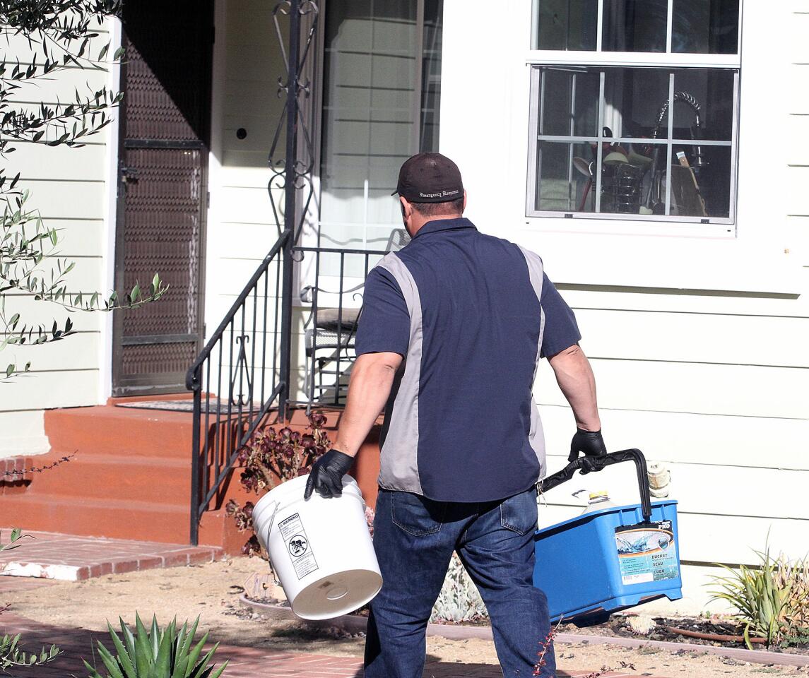 A man with Emergency Response Crime Scene Cleaning walks with supplies into the house at the scene of a murder-suicide on the 5000 block of Crown Avenue in La Cañada Flintridge on Monday, Sept. 7, 2015. On Sunday night, a 5-year veteran of the Los Angeles County Fire Department shot and killed his wife, a 2-year veteran of the Sheriff's Department. He then killed himself at a county Fire Department facility in Pacoima, according to officials.