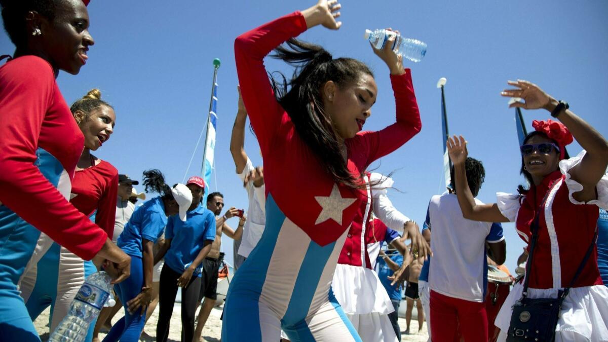 In this May 12, 2019, photo, Hotel Royalton staff entertain tourists during a beach party in Varadero, Cuba. The island nation has set a goal of drawing 5 million tourists in 2019.