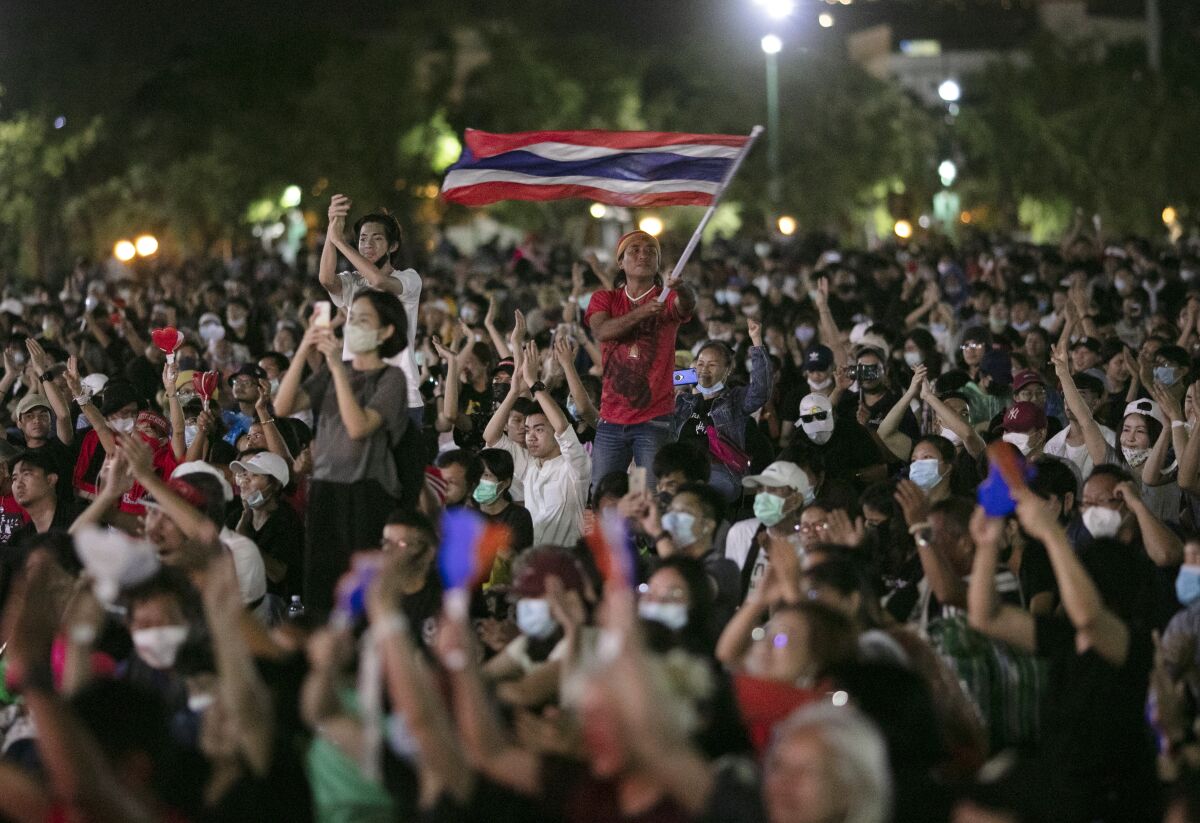 A Thai demonstrator waves the national flag amid a pro-democracy crowd in Bangkok.
