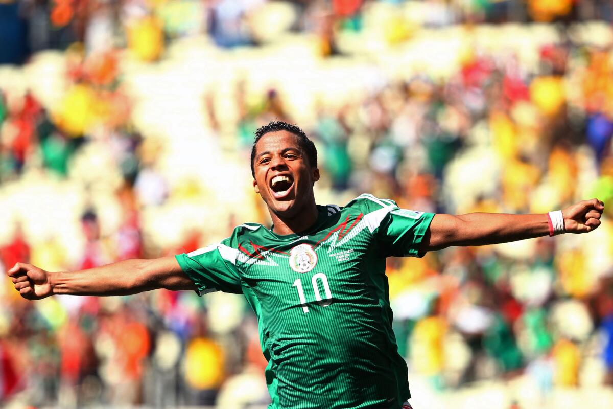 Giovani dos Santos of Mexico celebrates scoring his team's first goal during the 2014 FIFA World Cup's Round of 16 match against the Netherlands.