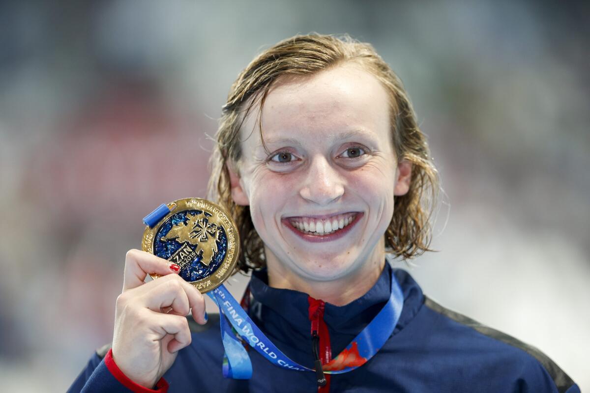 Katie Ledecky shows off her gold medal after winning the 800-meter freestyle at the world swimming championships on Saturday.