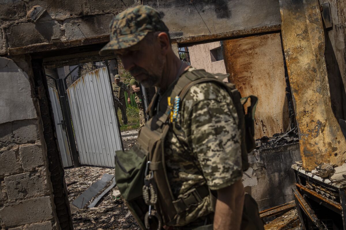 A Ukrainian army member inside a house destroyed by shelling