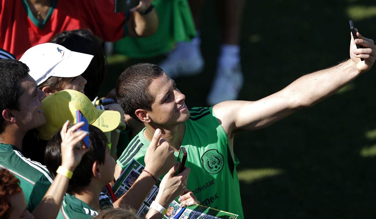 Mexico star Javier "Chicharito" Hernandez takes a selfie with fans after a training session in Santos, Brazil.