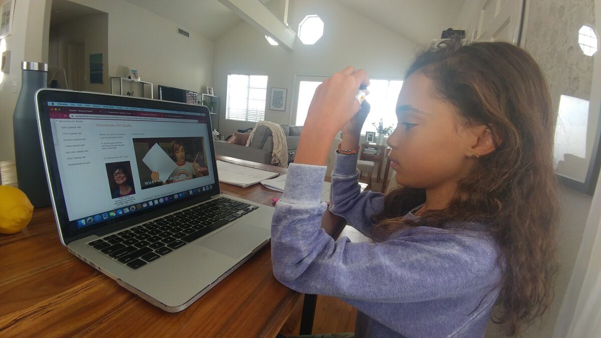 Parker Curry, 10, of Los Angeles uses a laptop to do her schoolwork online.