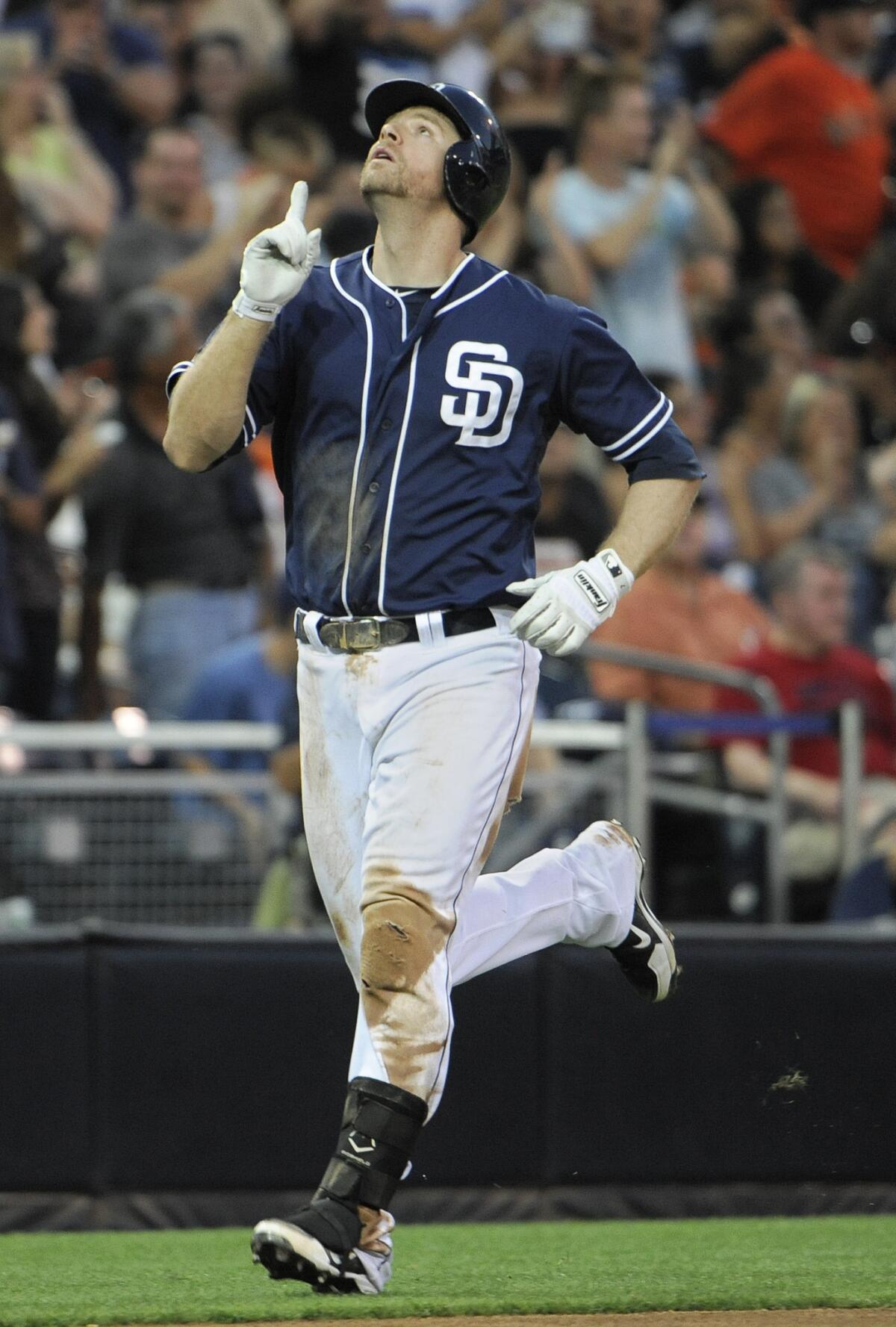 Padres slugger Chase Headley points skyward after hitting a two-run homer in a game against the Giants.