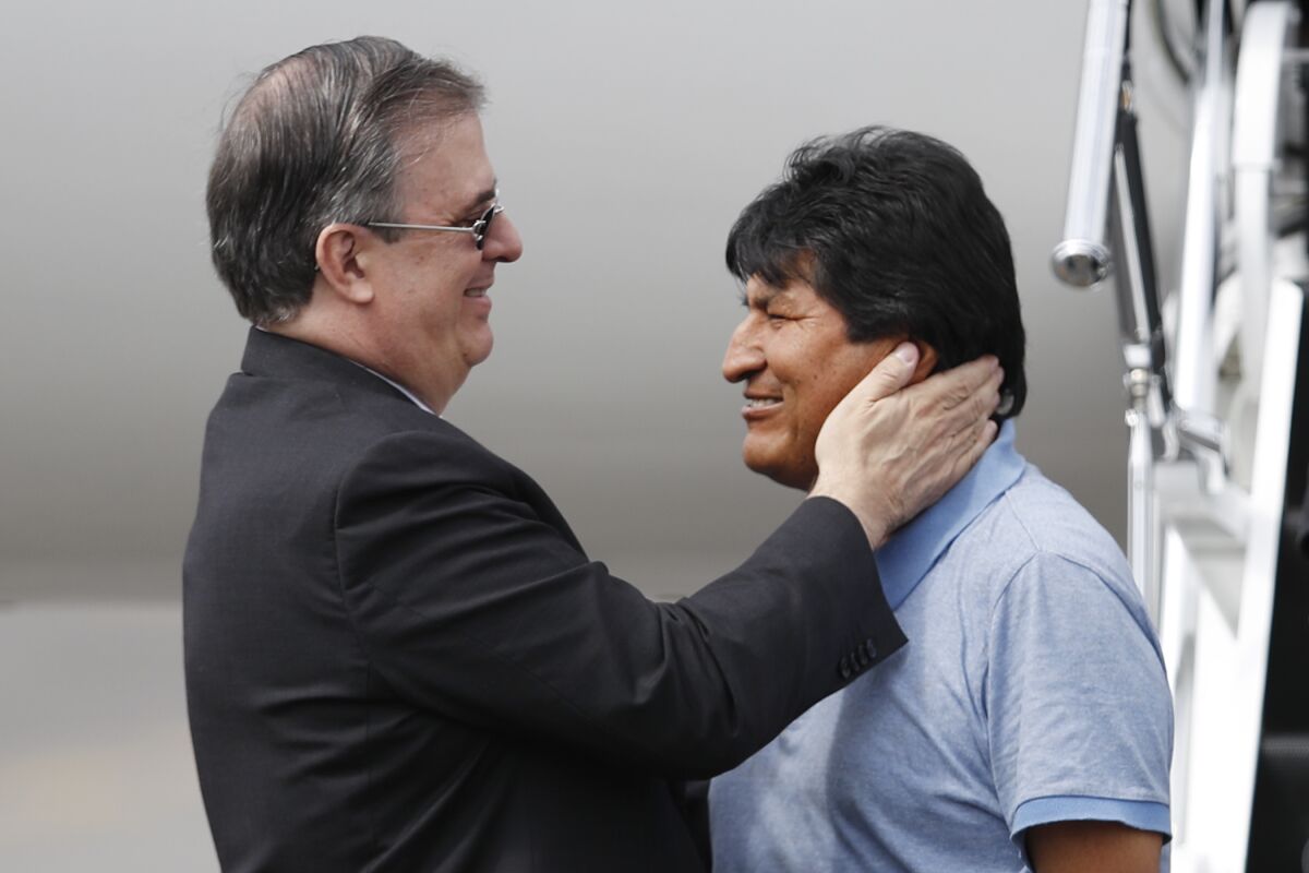 Mexican Foreign Secretary Marcelo Ebrard, left, welcomes former Bolivian President Evo Morales upon his arrival in Mexico City on Nov. 12, 2019. 