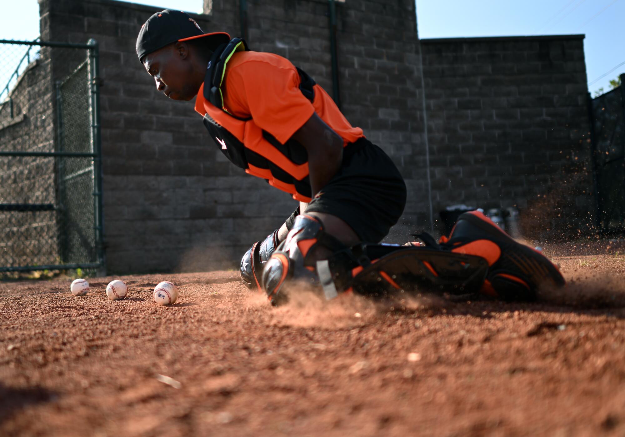 Frederick Keys player Dennis Kasumba practices his sliding as a catcher during a workout.