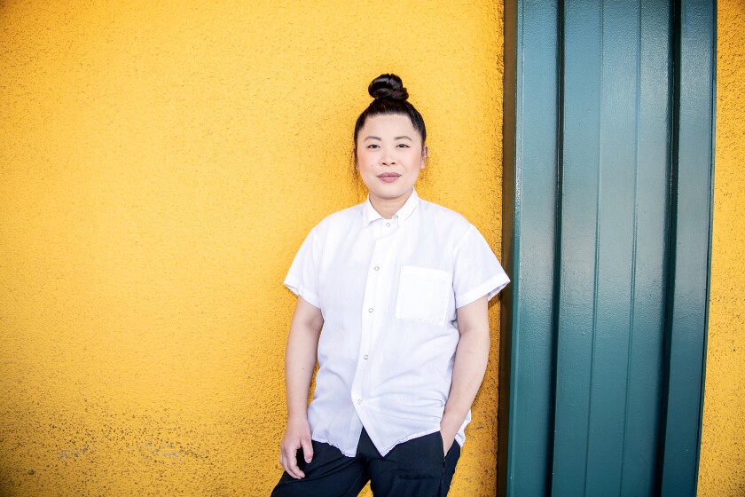 Chef Mei Lin stands against a yellow wall.