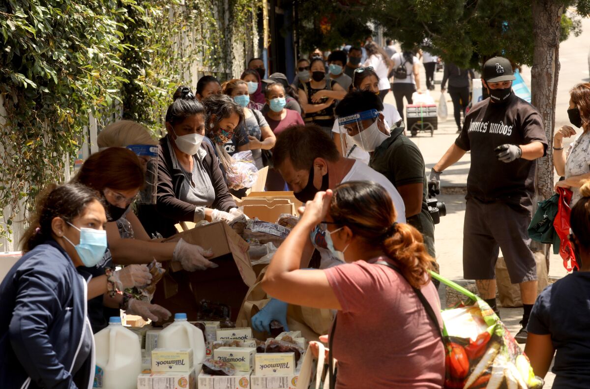 Members of Homies Unidos put food in bags for needy families in Los Angeles' Koreatown.