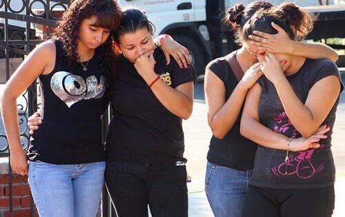 Students from Grant High School in Van Nuys gather outside the Sun Valley house where the throats of their classmate, Diana Moreno, and her sister Edith were slashed.