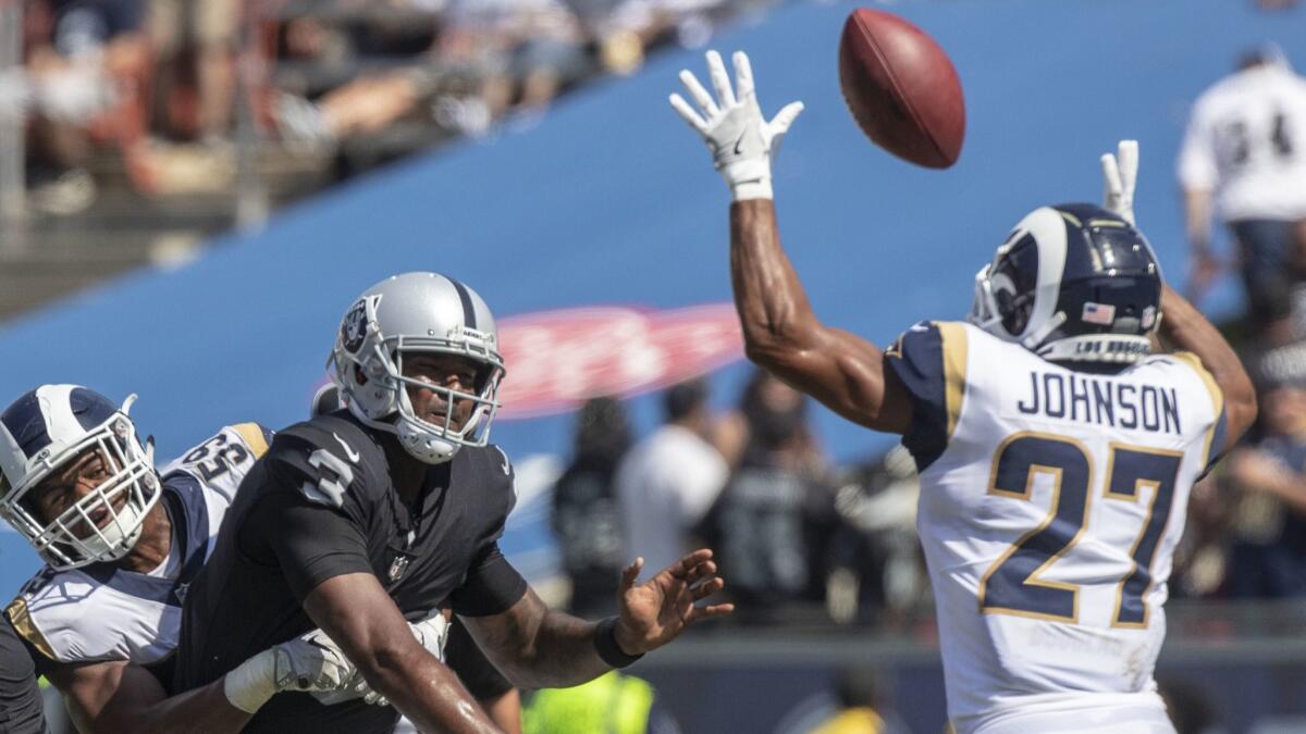 Rams' Micah Kiser, left, pressures Raiders quarterback EJ Manuel, center, as Isaiah Johnson, right, disrupts a pass.