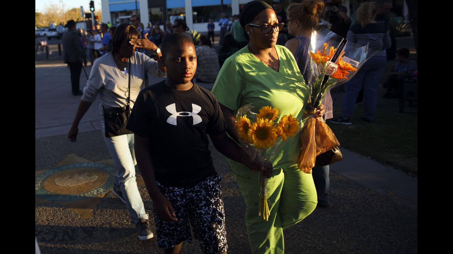 Ebony Reed, right, and her son, Jaden Reed, 10, walk to the station to leave flowers as community members gathered to mourn the death of Los Angeles County Sheriff's Sgt. Steve Owen. Owen was fatally shot while responding to a burglary call in Lancaster earlier this week.