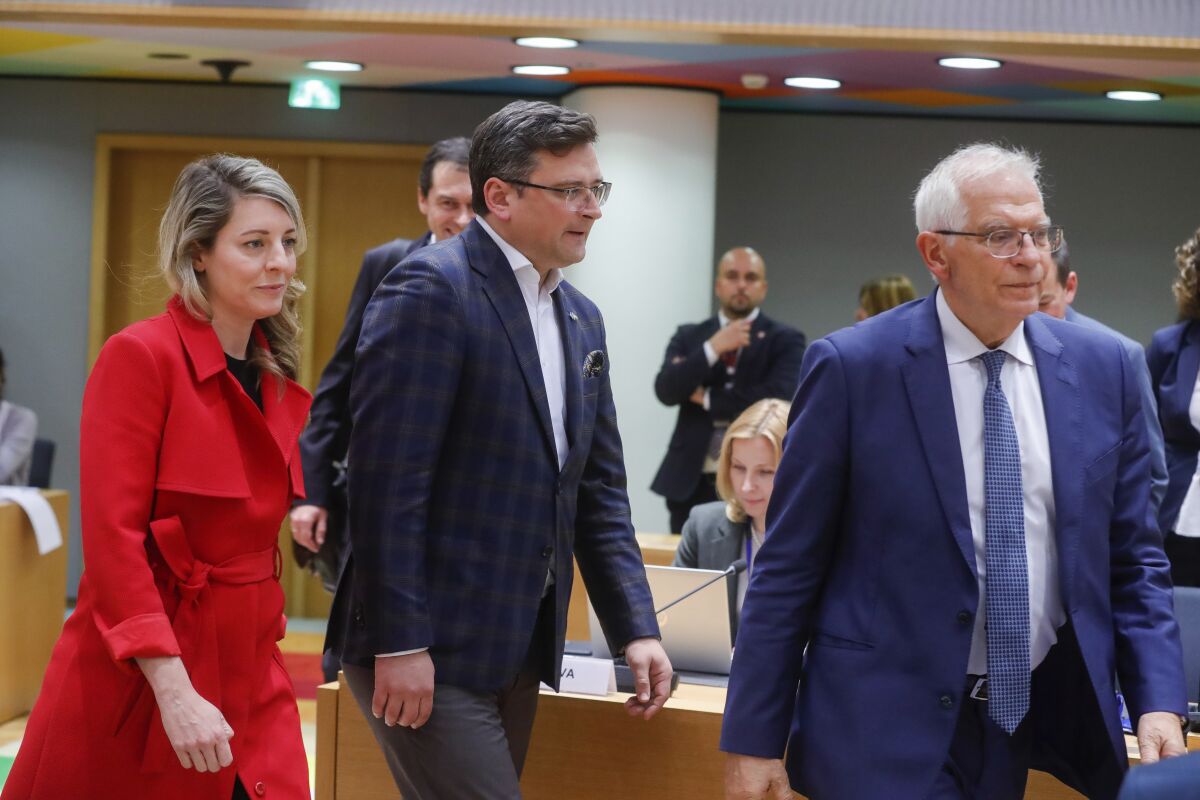 Ukraine's foreign minister Dmytro Kuleba, center, Canada's foreign minister Melanie Joly, left, and European Union foreign policy chief Josep Borrell arrive at a meeting of EU foreign ministers at the European Council building in Brussels, Monday, May 16, 2022. European Union foreign ministers on Monday will discuss current affairs and have an exchange of views on the Russian aggression against Ukraine and the Global Gateway. (Stephanie Lecocq/Pool Photo via AP)