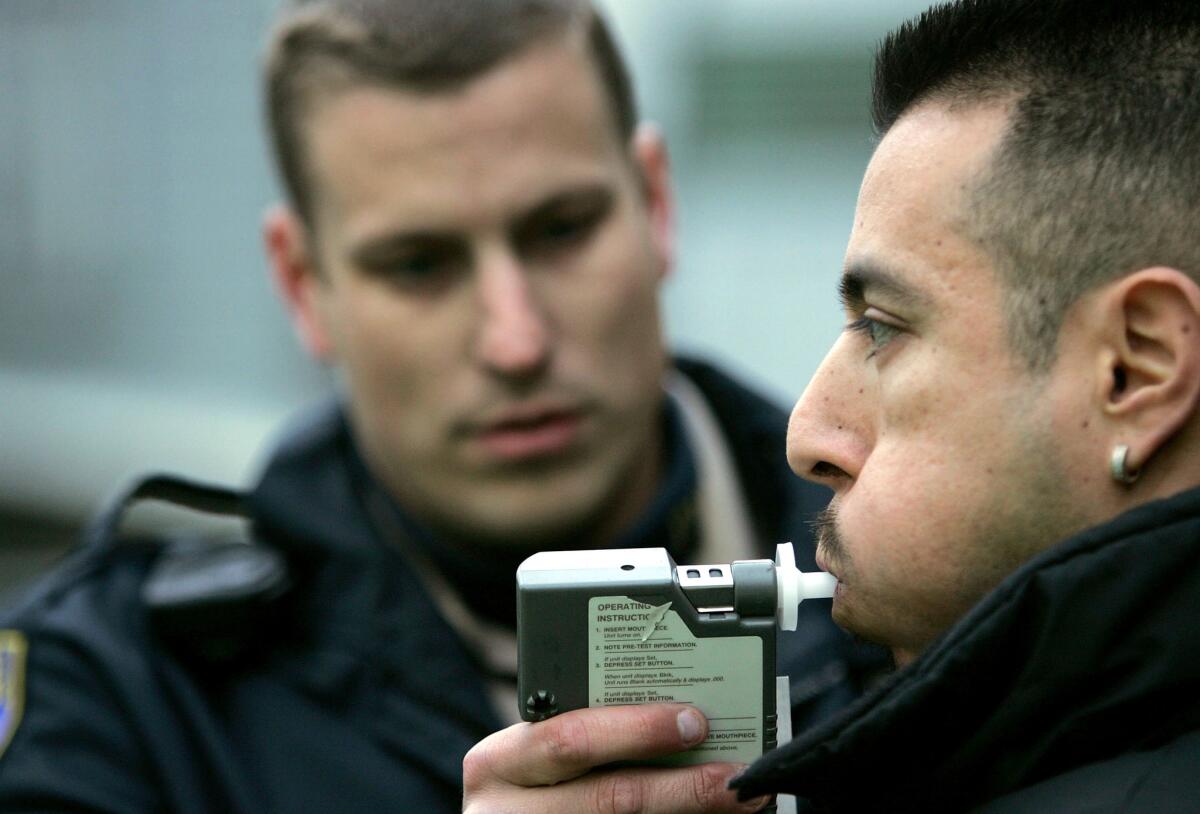 A California Highway Patrol officer administers a breathalyzer test to a man at a sobriety checkpoint in San Francisco.