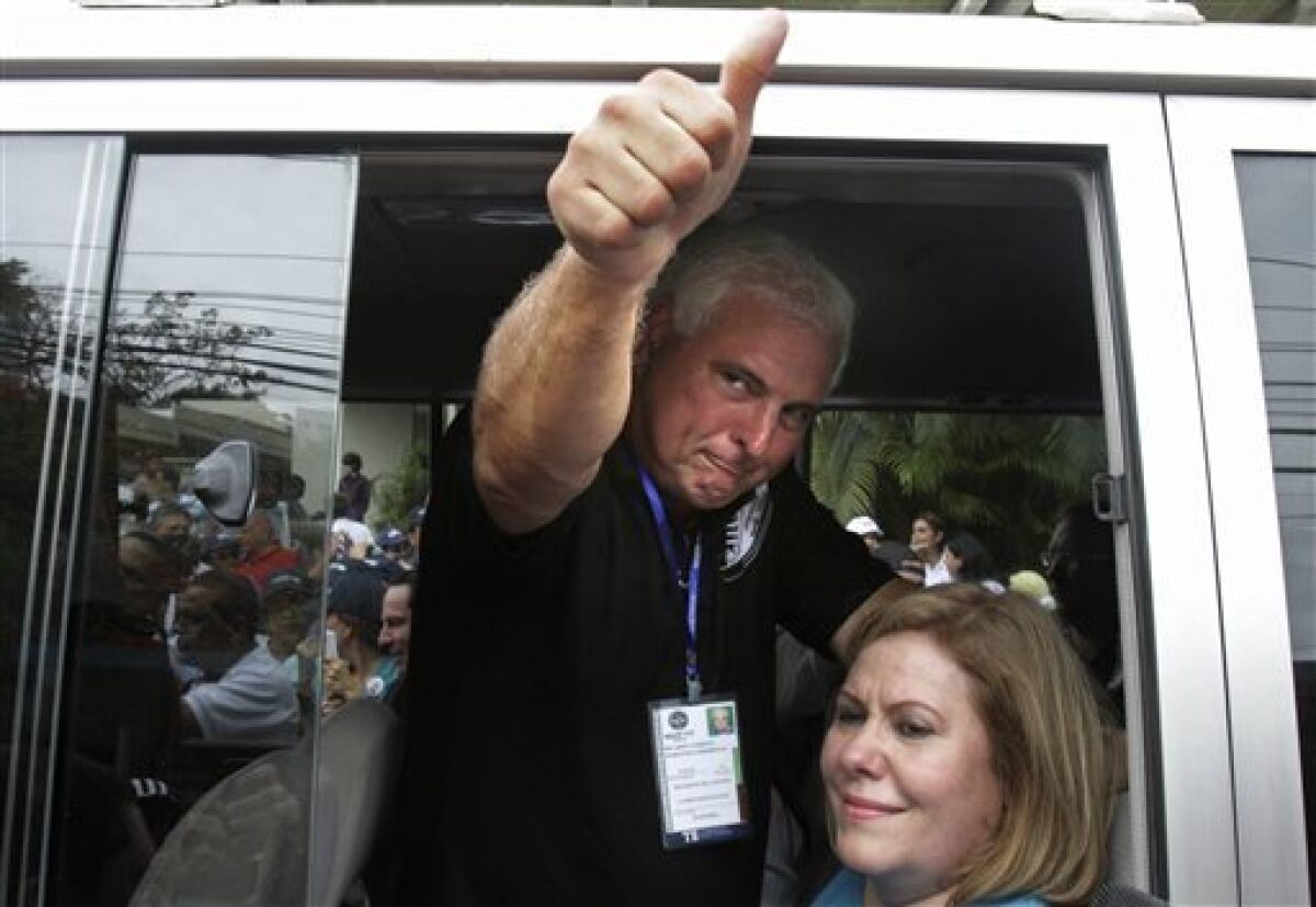 Ricardo Martinelli, left, presidential candidate of the Democratic Change party, gives a thumbs-up after voting during presidential elections in Panama City, Sunday, May 3, 2009. (AP Photo/Esteban Felix)