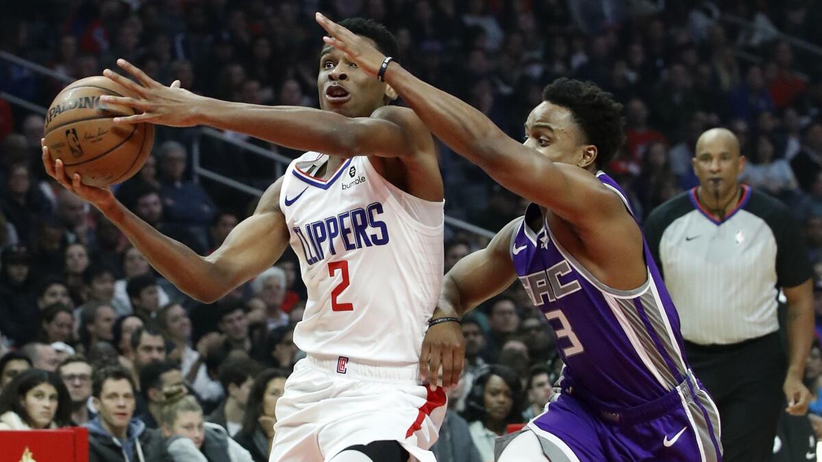 Clippers guard Shai Gilgeous-Alexander drives to the basket against Kings guard Yogi Ferrell in the first quarter.