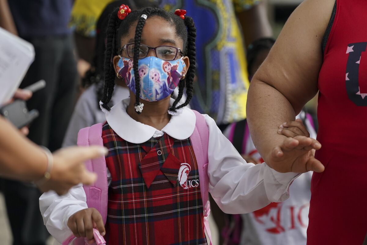 Students wear protective masks as they arrive for classes at the Immaculate Conception School while observing COVID-19 prevention protocols, Wednesday, Sept. 9, 2020, in The Bronx borough of New York. (AP Photo/John Minchillo)