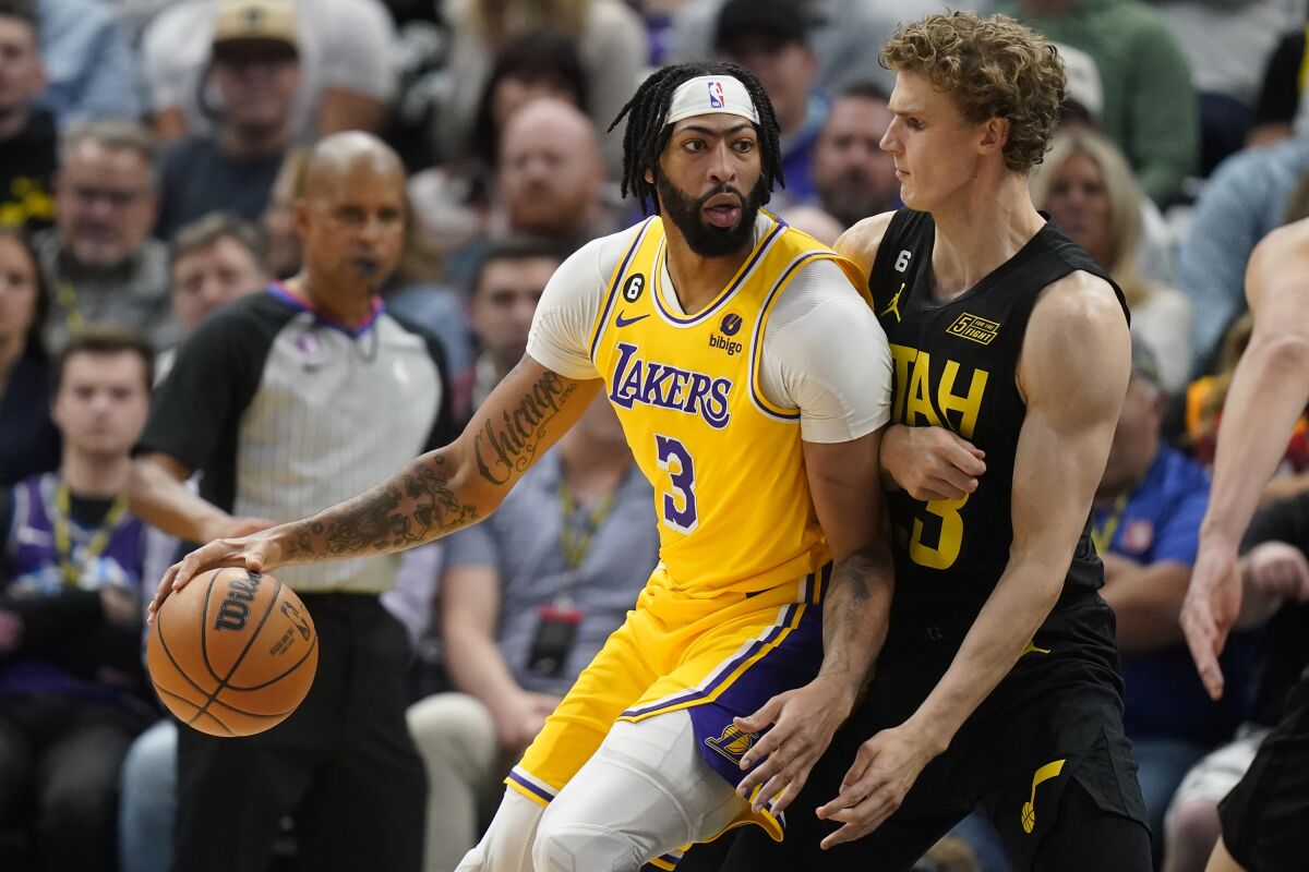 Lakers forward Anthony Davis dribbles the ball while posted up against Jazz forward Lauri Markkanen.