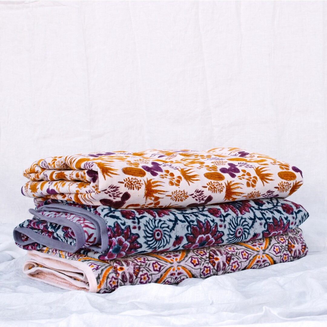 A pile of velvet blankets, hand block printed by artists in Jaipur, India.