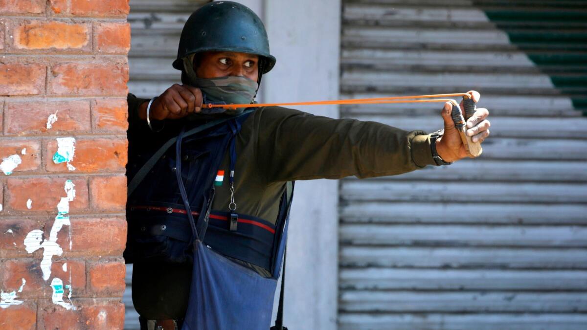 An Indian paramilitary soldier uses a slingshot to launch stones at Kashmiri Muslim protesters during clashes in Srinagar, the summer capital of Indian Kashmir, on May 25.