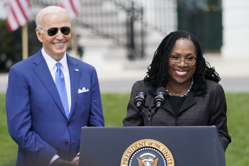 FILE - President Joe Biden listens as Judge Ketanji Brown Jackson speaks during an event on the South Lawn of the White House in Washington, April 8, 2022, celebrating the confirmation of Jackson as the first Black woman to reach the Supreme Court. On Friday, Sept. 30, 2022, Biden, Vice President Kamala Harris and their spouses will attend the ceremonial investiture for Justice Brown Jackson, the Supreme Court’s newest member according to a White House official. (AP Photo/Andrew Harnik, File)
