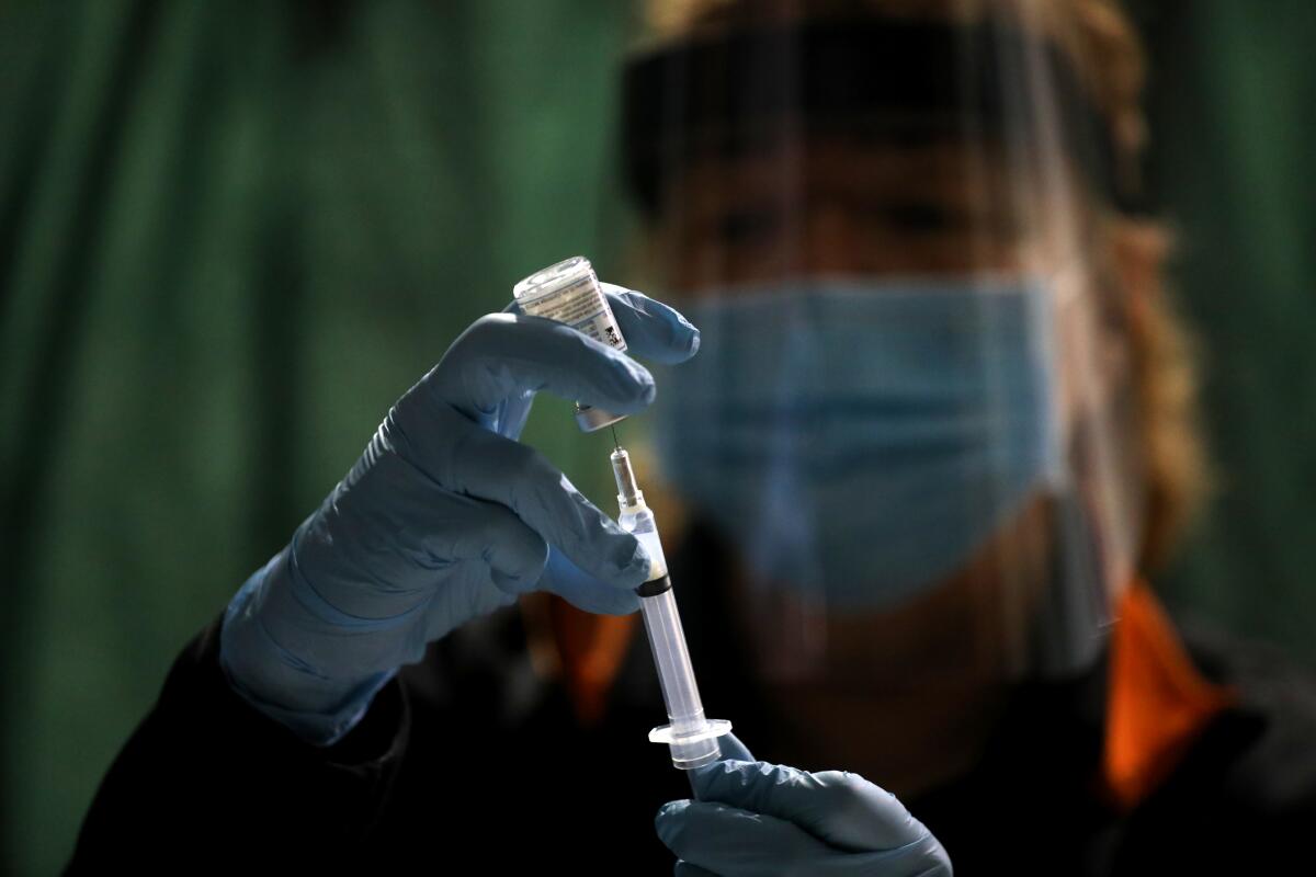 A nurse prepares a syringe with Moderna's COVID-19 vaccine