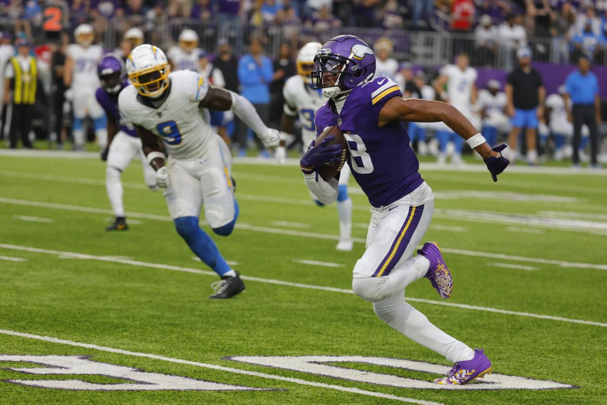 Vikings receiver Justin Jefferson (18) runs for a touchdown against the Chargers.