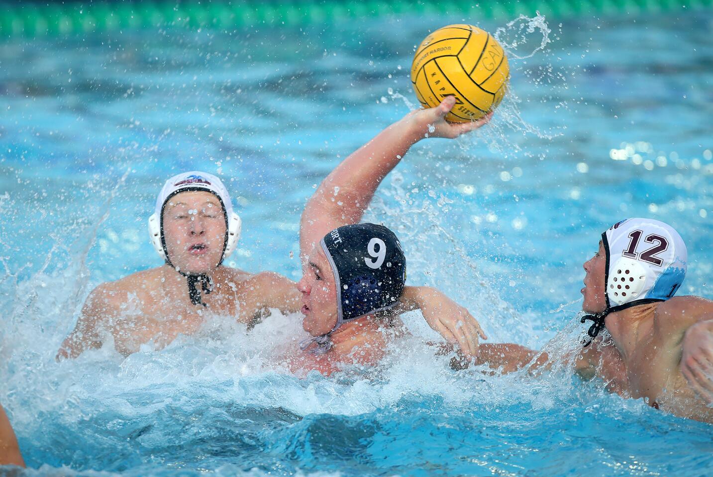 Newport Harbor's Ike Love is turns and shoots for a score despite the tight defense by Laguna Beach during the opening round of the CIF Southern Section Division 1 playoffs on Thursday at Newport Harbor.