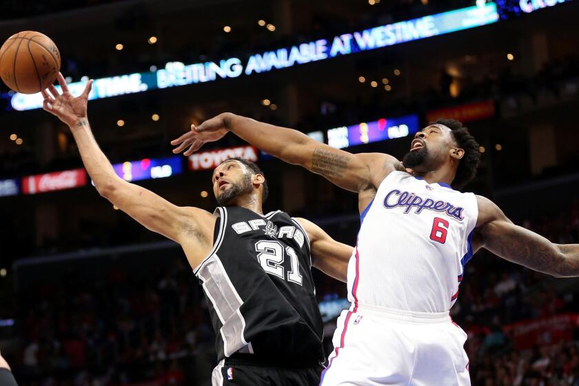 DeAndre Jordan and Spurs forward Tim Duncan chase a rebound during the Clippers' loss 111-107 to San Antonio in Game 5 of the playoff series.