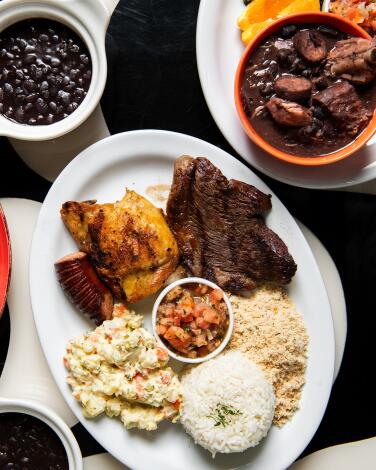 REDONDO BEACH, CA - NOVEMBER 07: BBQ plate (center) and Feijoada from Panelas Brazillian Cuisine on Tuesday, Nov. 7, 2023 in Redondo Beach, CA. (Mariah Tauger / Los Angeles Times)