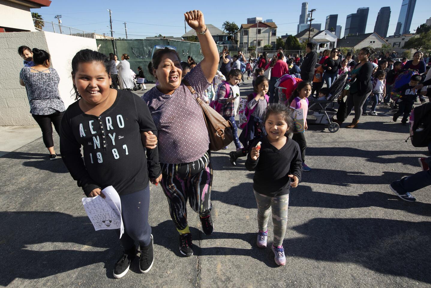 Arasele Gines, center, celebrates, after picking up her daughter, Arlene, 8, a 2nd grader at Union Avenue Elementary School in Los Angeles on the first day back after the teachers strike was settled. At right is her daughter, Stephanie, 4.