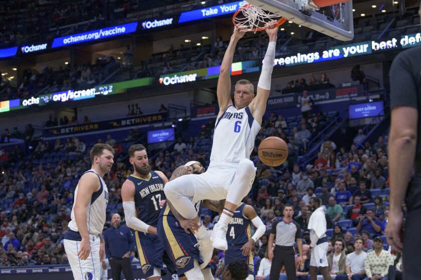 Dallas Mavericks center Kristaps Porzingis (6) dunks against the New Orleans Pelicans during the first half of an NBA basketball game in New Orleans, Wednesday, Dec. 1, 2021. (AP Photo/Matthew Hinton)