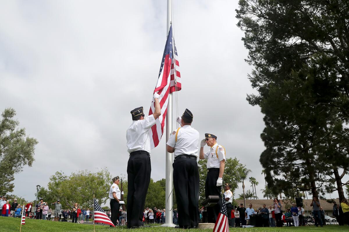 Members of American Legion Newport Harbor Post 291 honor guard raise the flag of the United States of America.