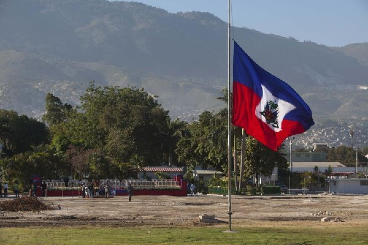 A Haitian national flag flies at half staff on the front lawn of the former National Palace, marking the third anniversary of a devastating earthquake.