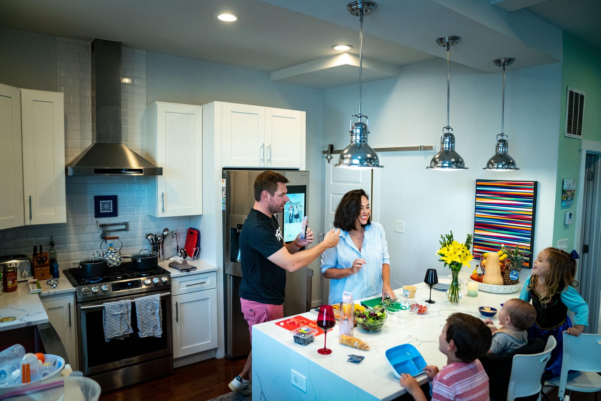 Rep. Eric Swalwell and Brittany Watts make snacks for their children in their kitchen.