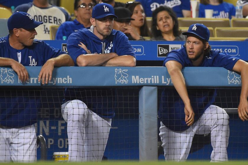 Dodgers ace Clayton Kershaw, right, chatting with catcher A.J. Ellis, left, and pitcher Brandon McCarthy, might not pitch again this season.