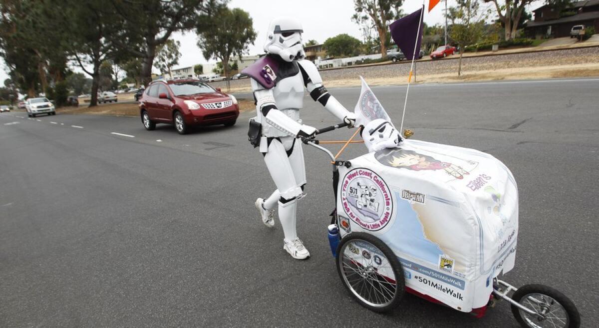 Kevin Doyle of Minnesota walks through Leucadia on Tuesday. He has spent the past month walking more than 600 miles down the California coast in his “Star Wars” Stormtrooper costume to Comic-Con in San Diego.