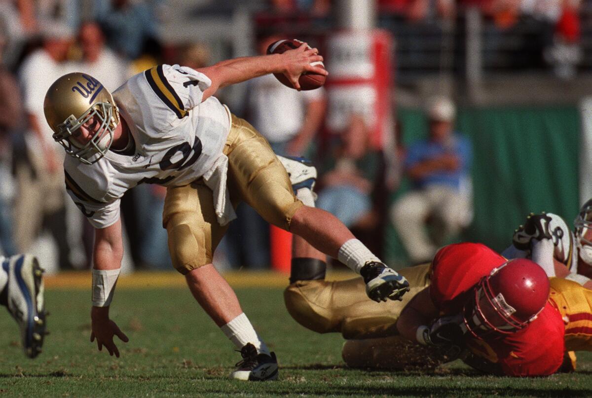 UCLA quarterback Cade McNown scrambles for a gain against USC.