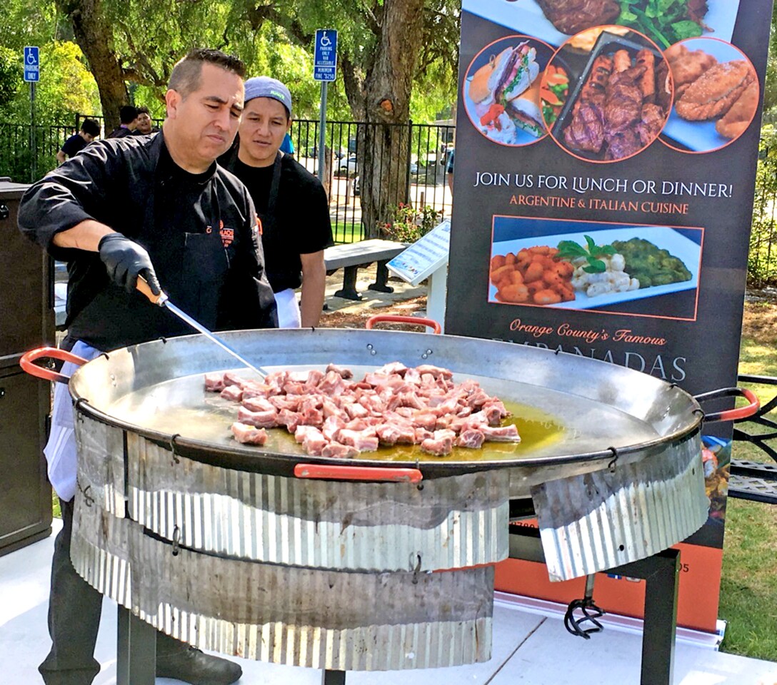 Chef Leo Razo begins cooking pork, the first main ingredient to create paella for about 20 students and community members.