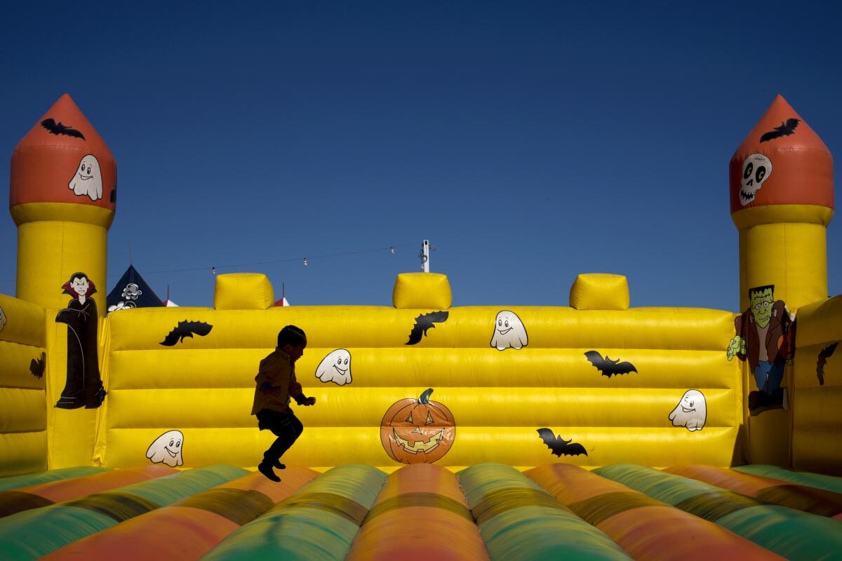 A boy plays in the bounce house at a pumpkin patch.