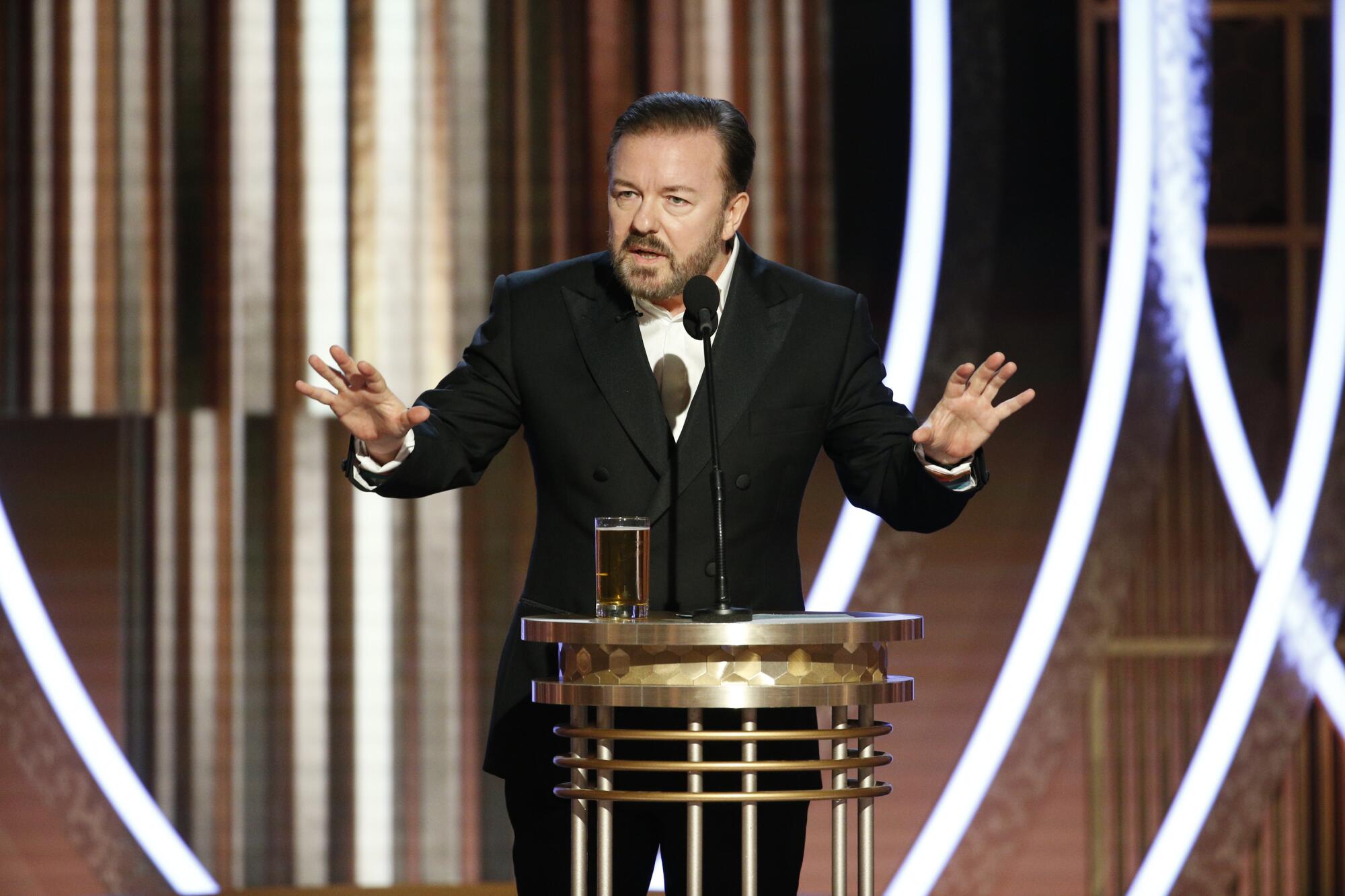 Host Ricky Gervais stands on stage at the Golden Globe Awards