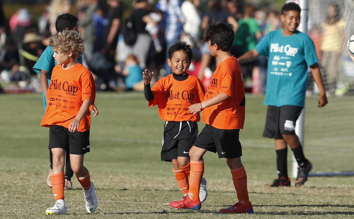 Davis Elementary's Isaak Duarte, right, high-fives Jack Kondo after he scored a goal during a boys' third- and fourth-grade Gold Division pool-play match against Mariners Christian School at the Daily Pilot Cup on Wednesday.