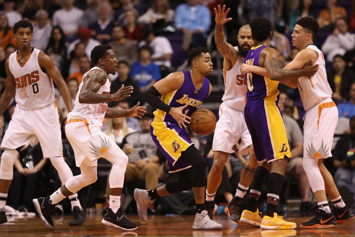 D'Angelo Russell, de los Lakers de Los Ángeles trata de superar la defensa de los Suns de Phoenix .