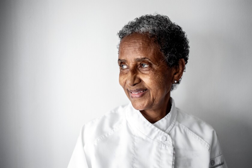 A portrait of a smiling gray-haired woman looking to her right.